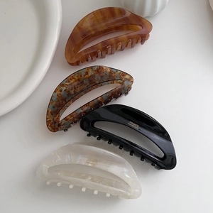 Detailed macro view of four vintage acetate hair claws in amber and marble finishes