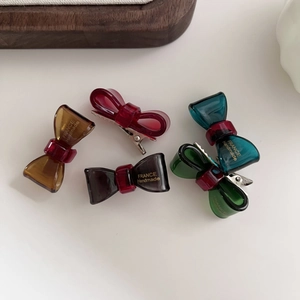 Detailed macro view of handmade translucent acetate bow hair clips in assorted colors
