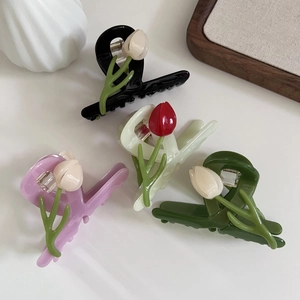 Close-up of four acetate tulip hair claws in black, purple, cream, and green colors