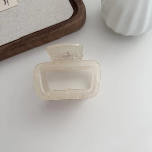 Pince à cheveux rectangulaire crème minimaliste avec ressort argenté sur plateau