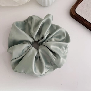 Elegant mint green satin hair scrunchie with soft pleats displayed on a white background