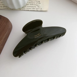 Close-up of olive green acetate hair claw with gold Barrette La France lettering