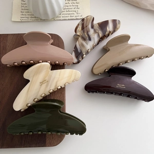 Set of six large earth-tone acetate hair claws featuring Barrette La France gold lettering