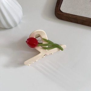 Close-up of a cream tulip hair claw clip with red flower and green stem details