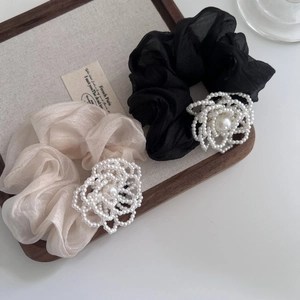 Dettagli dei fiori di perle su elastici per capelli in rete plissettata neri e beige