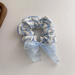 Chouchou en dentelle à rayures bleues avec nœud sur fond épuré et minimaliste