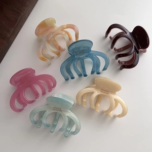 Detail view of colorful acetate hair claws showing the gold France Handmade stamp