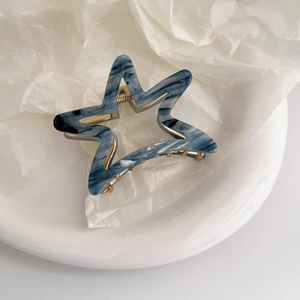 Star shaped hair claw clip with blue marble acetate texture and gold metal frame