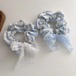 Vue détaillée des chouchous en coton à rayures bleues et dentelle avec nœuds