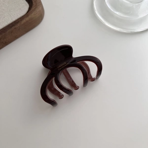 Macro detail of brown acetate hair claw featuring gold France Handmade lettering
