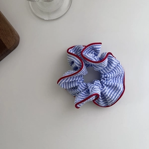 Blue and white striped scrunchie with red edges in a minimalist fabric hair accessory style