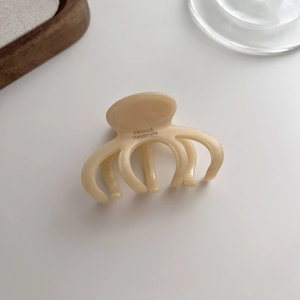 Detail of cream acetate hair claw clip with FRANCE Handmade engraving in minimalist setting