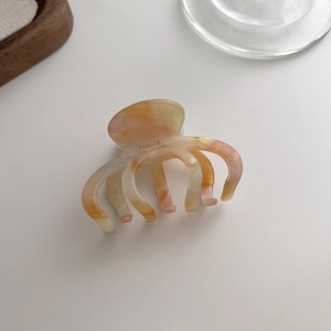 Detailed close-up of marble pattern acetate hair claw clip with France Handmade text