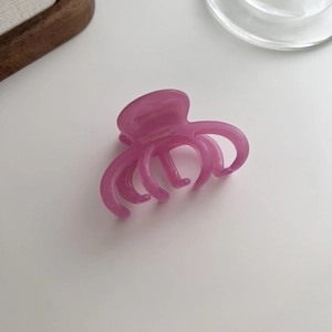Close-up of pink marble acetate hair claw clip with multi-tooth clamp and France handmade text