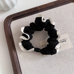 Elegant black scrunchie with white lace trim for stylish low ponytail hairstyles