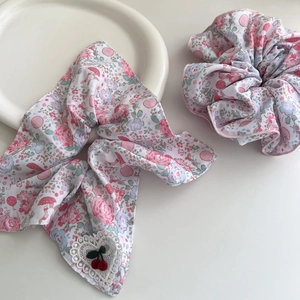 Close-up of pink floral hair scrunchies with cute cherry embroidery and lace detail