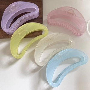 Detail view of five assorted pastel macaron jelly hair claws in a row for thick hair