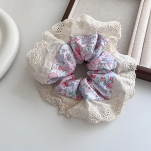 Detail of floral scrunchie with pink blossoms and elegant cream lace edging texture