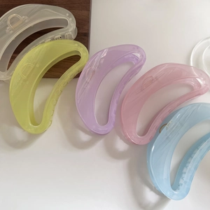 Macro view of large translucent jelly hair claws in five pastel colors on white background