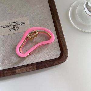 Detailed view of the bright pink acetate claw clip with a premium golden metal frame