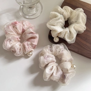 Close-up of dual-layer mesh scrunchies with pearls in cream and pink tones