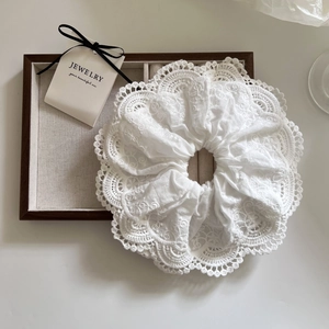 Large white lace scrunchie with floral embroidery on a vintage display tray