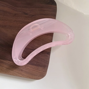 Detailed view of pink translucent crescent hair claw clip with sturdy metal spring