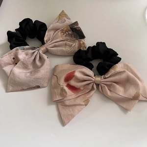 Detailed macro view of retro floral bow hair scrunchies with elegant vintage patterns