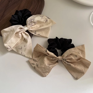 Detail view of Chinese style bow scrunchies with bamboo leaf patterns in silk fabric