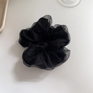 Close-up of elegant black double-layered mesh hair scrunchie with soft pleated texture