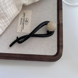 Minimalist black banana clip hair accessory with elegant beige pearl detail for women