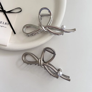 Elegant silver bow hair claw clips with pearls for a minimalist bun hairstyle look