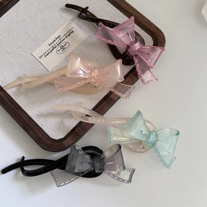 Détail de quatre barrettes à cheveux à nœud transparent rose champagne vert et noir