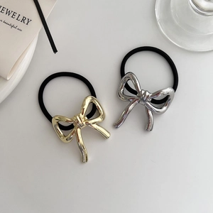 Detail of minimalist metallic bow hair ties in gold and silver finish with high elasticity