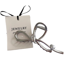 Elegant silver metal hair claw clip with pearl accent and irregular ribbon knot design