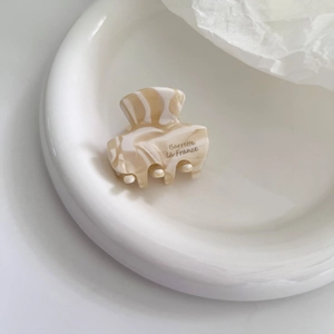 Detailed macro view of small marble acetate hair claw clip with Barrette la France text