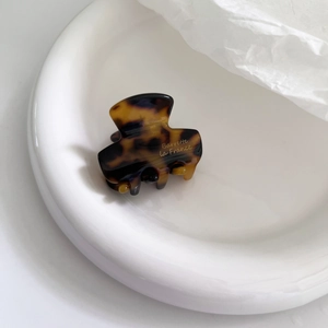 Close-up of tortoiseshell acetate hair claw clip with gold Barrette La France text