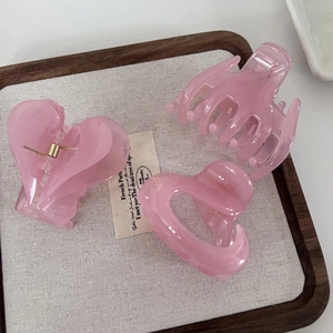 Detailed set of three translucent pink jelly hair claws with golden metal springs