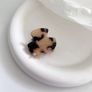 Close-up of tortoise shell pattern mini acetate hair claw with gold engraved lettering