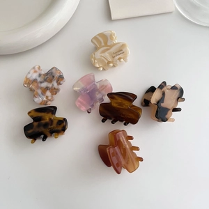 Close-up of assorted mini acetate hair claws with marble and tortoiseshell patterns