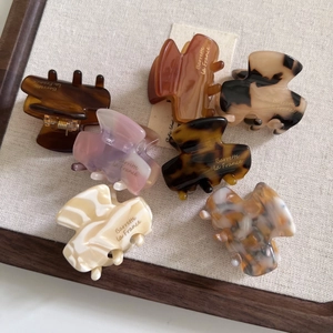Detailed macro of acetate hair claws featuring elegant marble and tortoiseshell textures