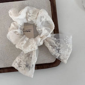 French style white lace scrunchie with mesh embroidery and pearls on a wooden tray