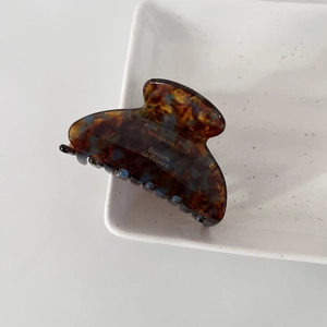 Détail d'une pince à cheveux en acétate écaille avec texte doré Barrette la France