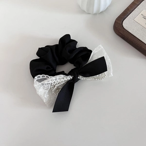Chouchou élégant en satin noir avec nœud en dentelle blanche et accents de perles