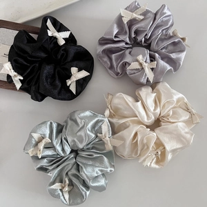 Set of four satin scrunchies in black, grey, green, and white with lace bow details