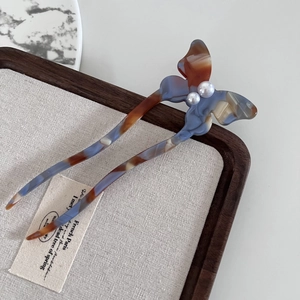 Elegant U-shaped butterfly hair pin in marble acetate finish with white pearl accents