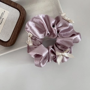 Elegant purple satin scrunchie with white silk bows for a balletcore hairstyle