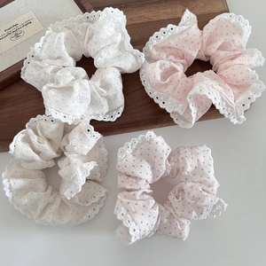 Detail showing lace-edged polka dot scrunchies in light blue, pink, green, and purple shades