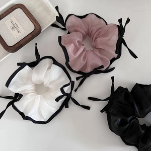 Vue détaillée des chouchous en organza rose, blanc et noir avec bordure contrastée
