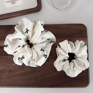 White oversized scrunchies with black bow prints and sparkling rhinestones set